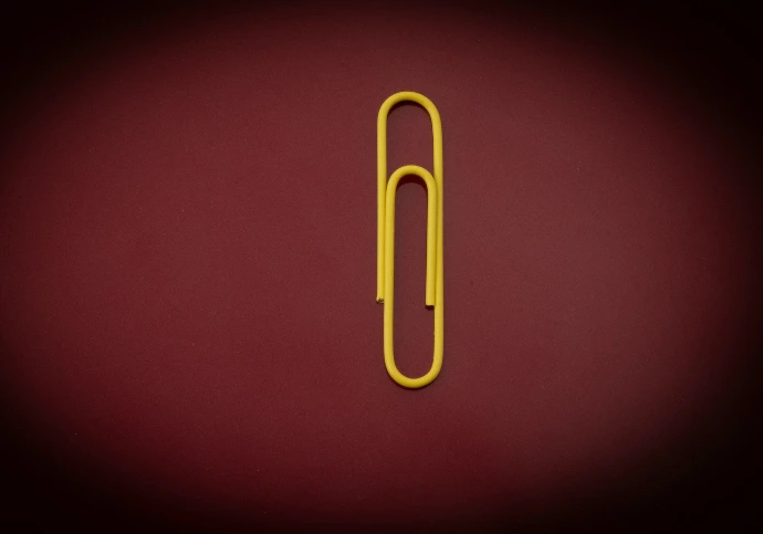 yellow paper clip on red textile